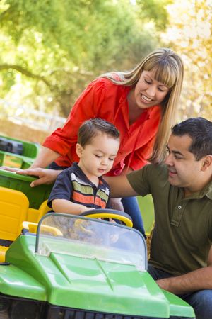 Young Boy Enjoys Toy Tractor with Parents