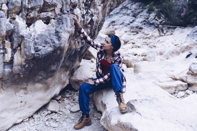 Positive woman sitting on stone