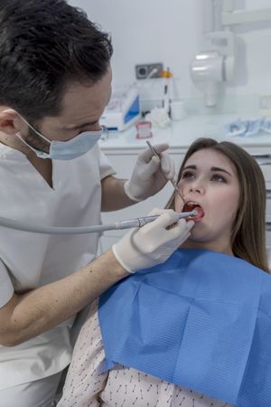 Portrait of a dentist and a teenage patient in the dentist clinic, vertical