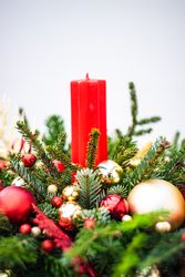 Side view of Christmas festive center piece with fir and gold & red baubles
