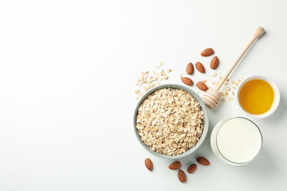 Composition with oatmeal flakes on plain background, top view. Cooking breakfast