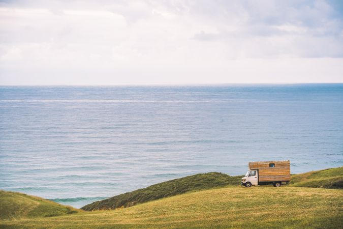 Landscape of empty meadow with passing truck near seaside