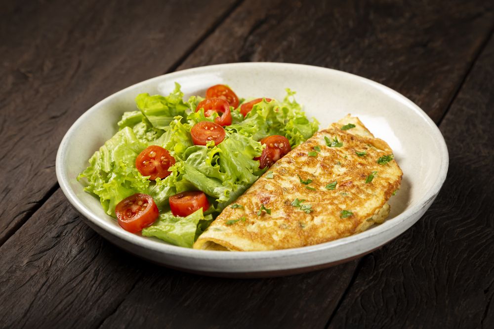 Omelet with cheese and lettuce and tomato salad.