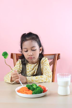Asian Little Cute Girl Refuses to Eat Broccoli Healthy Vegetables.