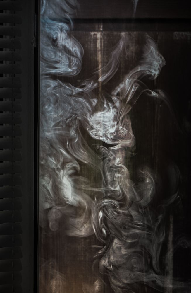 Smoke swirling next to a wooden wall