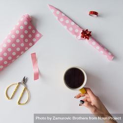 DIY gift wrapped knife in pink paper on table with coffee cup 41jgOb