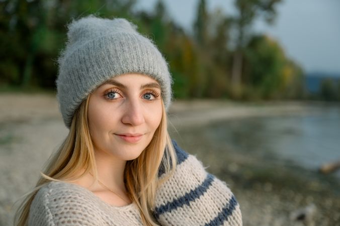 A young woman breathes clean air, looks at the sky with a smile and closed eyes