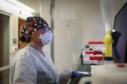 Shiprock, NM - USA, Dec. 23, 2020: Nurse reviews chart on computer in full PPE