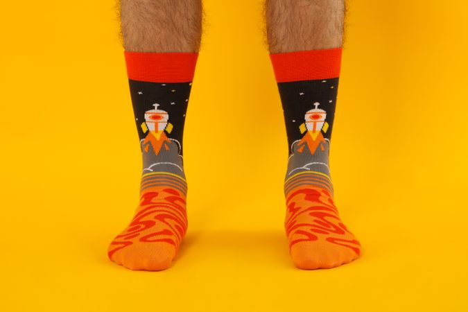 Male legs in socks on yellow background