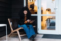Smiling Black woman with tablet on veranda