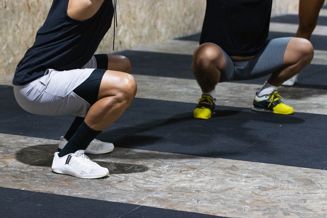 Sportspeople doing squats during training in sports club