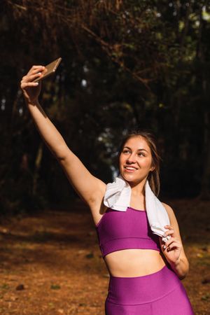 Smiling woman taking selfie on smartphone