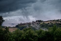 Low clouds over a French village surrounded by green bushes