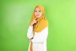 Asian Young Hijab Woman Pouting and Thinking Looking at Camera