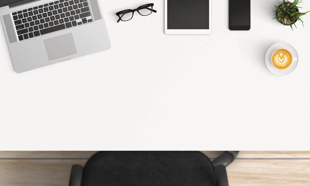 Modern workplace with laptop, coffee cup and smartphone or tablet copy space on table background. Top view. Flat lay style.