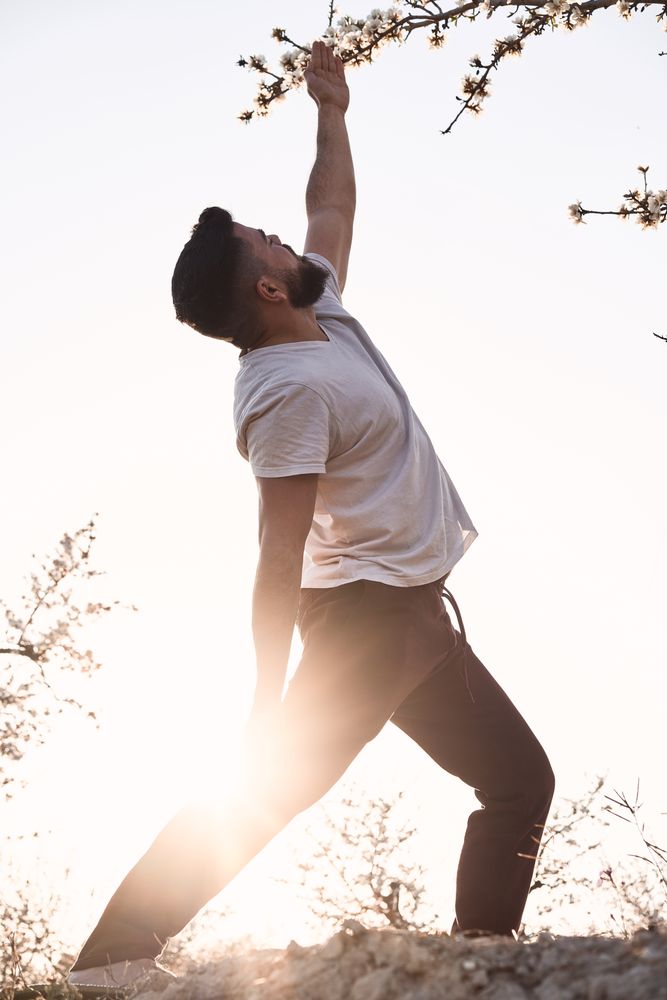 Man doing yoga in spring garden