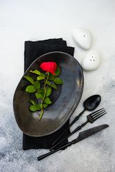 Top view of dark plate with red rose