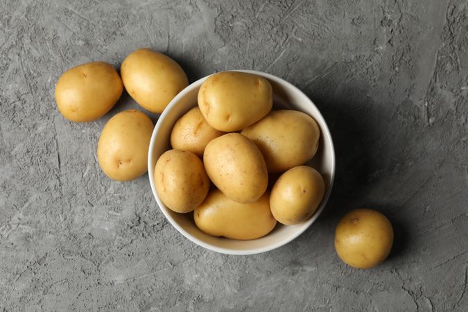 Top view of fresh potatoes in ceramic bowl