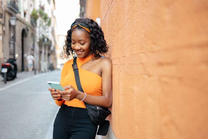 Portrait of a young Black woman using smartphone in the street