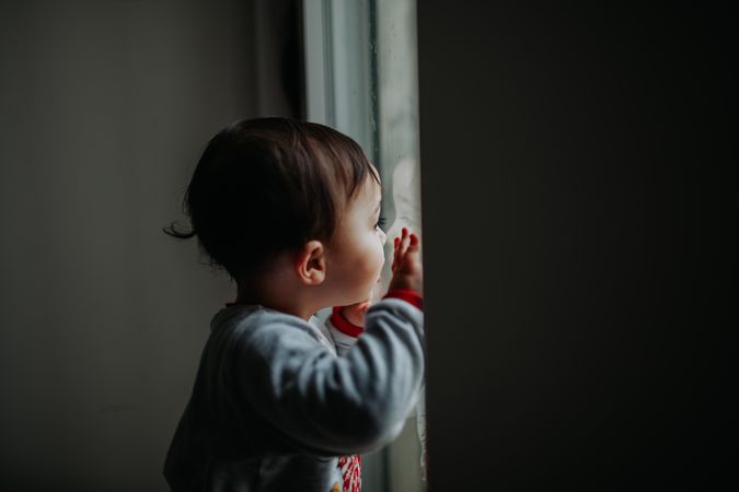 Little toddler looking out the window