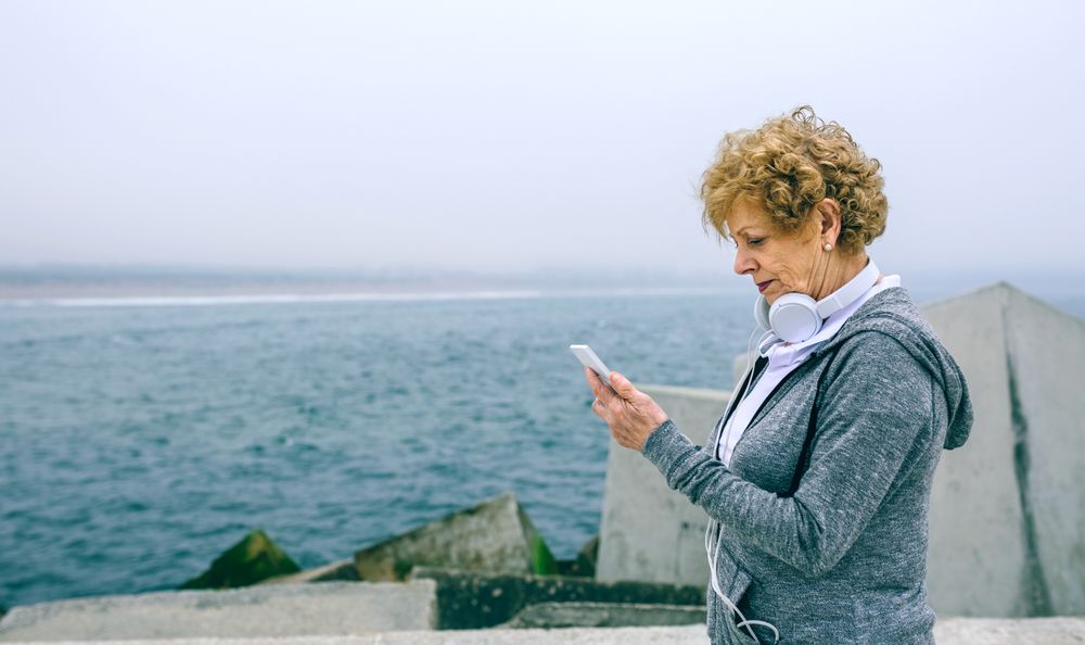 Older sportswoman looking at her smartphone