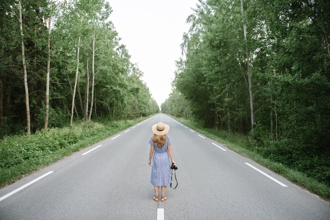 Young female photographer on forest road