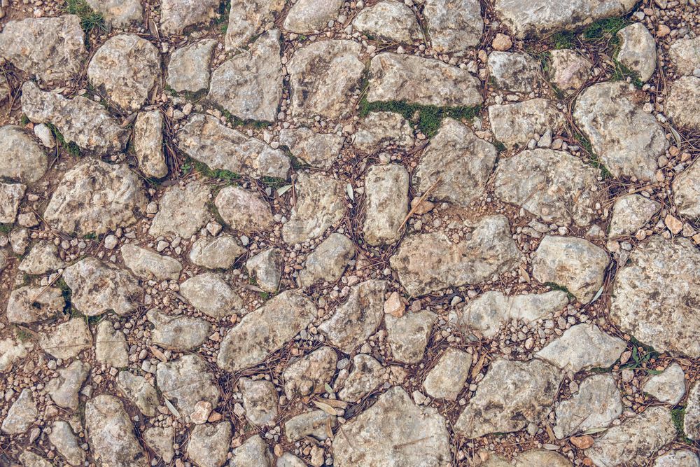 Old road with rough textured stones as background