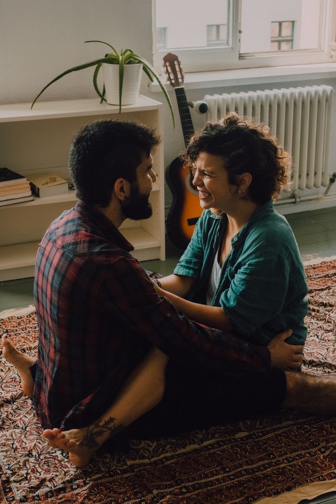 Loving couple embracing while sitting on apartment floor
