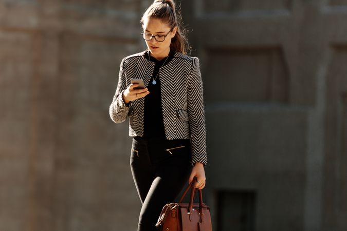 Businesswoman using mobile phone while commuting to office
