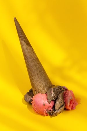 Ice cream cone dropped on yellow background