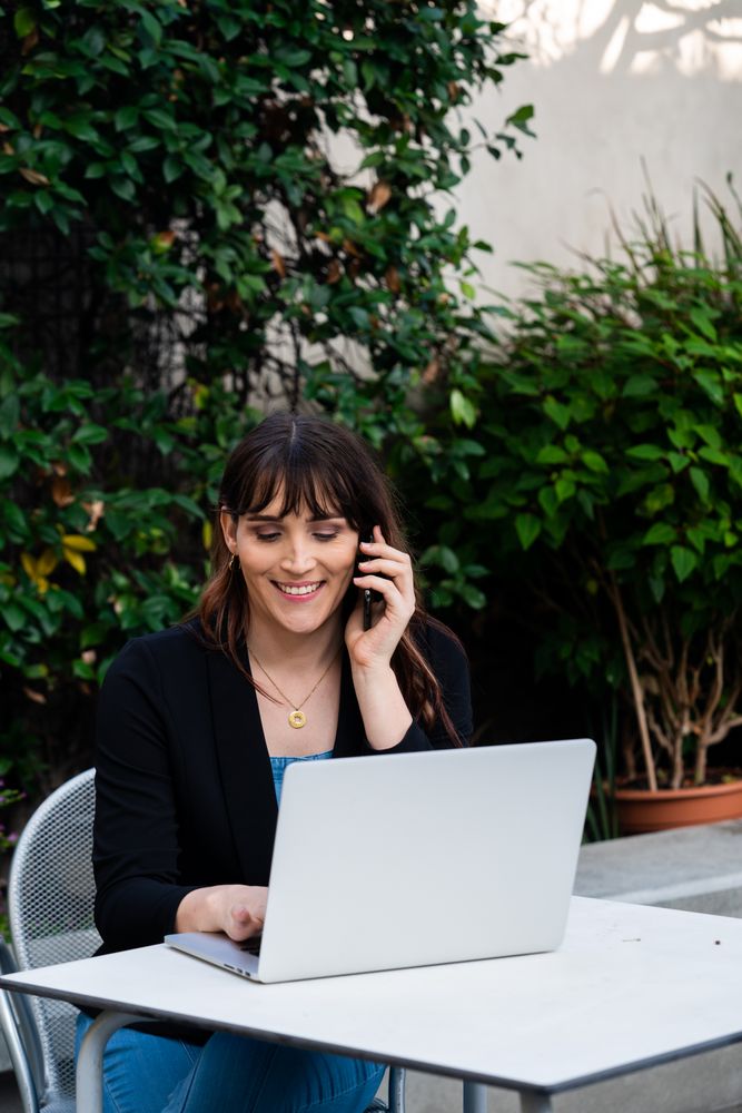 Female working outside with smartphone and laptop