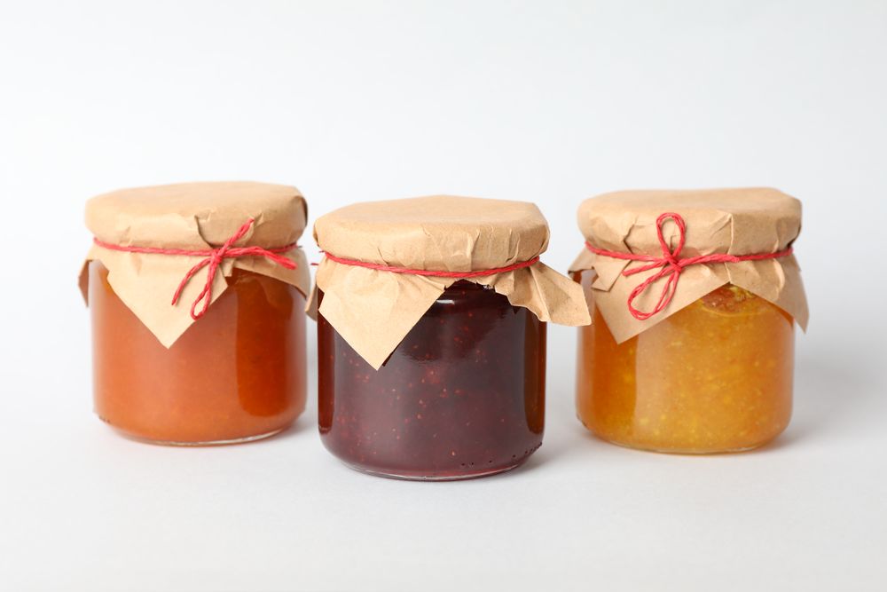 Glass jars with jam on blank background. Sweet food