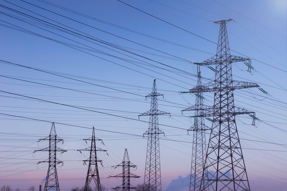 High Voltage Power Lines at Sunset Over Open Landscape