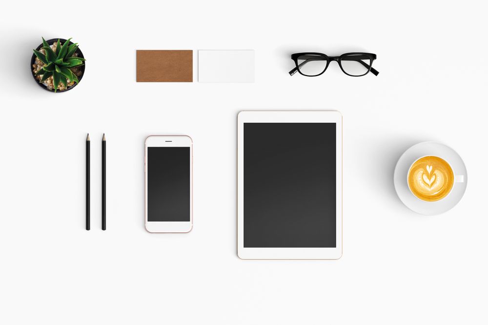 Modern workspace with coffee cup, smartphone, paper, notebook, tablet copy space