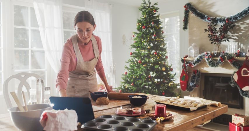 Portrait of a Woman Using Digital Tablet to Follow an Online Recipe While Cooking Dinner for Christmas Eve.