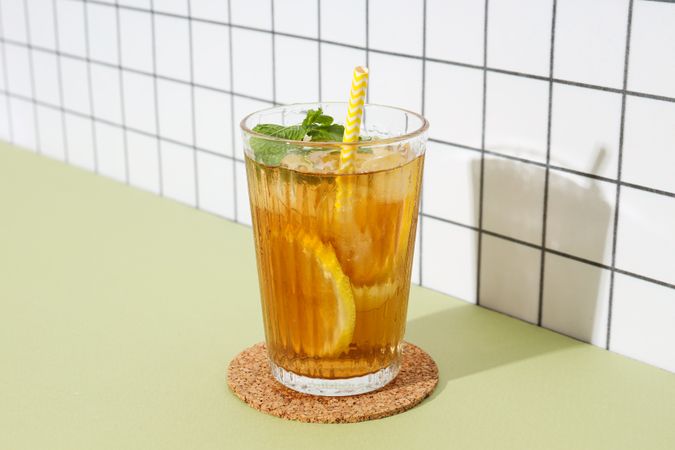 A glass of delicious cold tea on a plain background