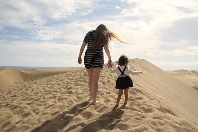 Mother and daughter standing in desert