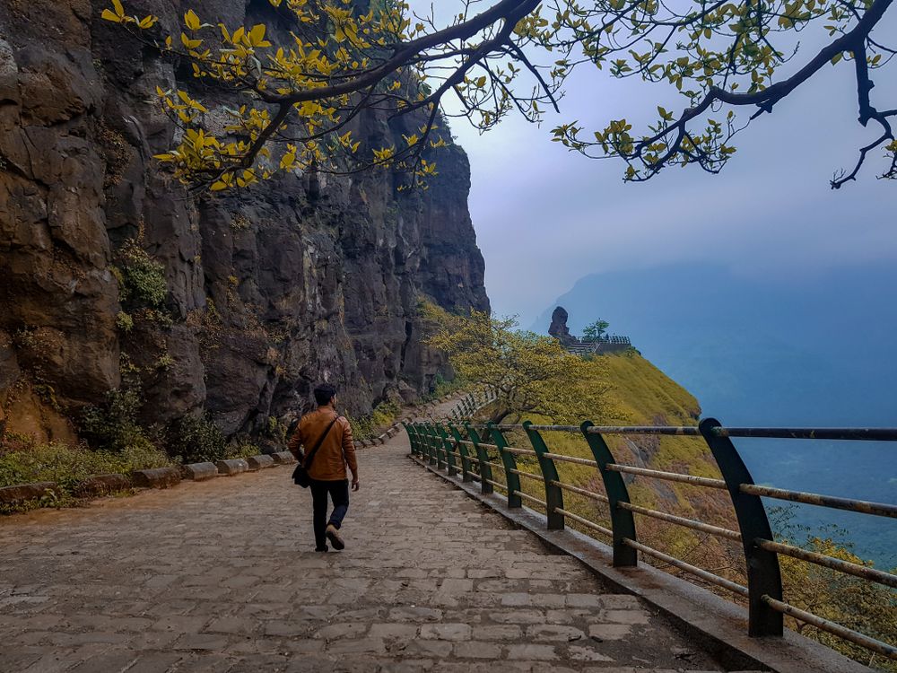 Man in brown jacket walking on pathway