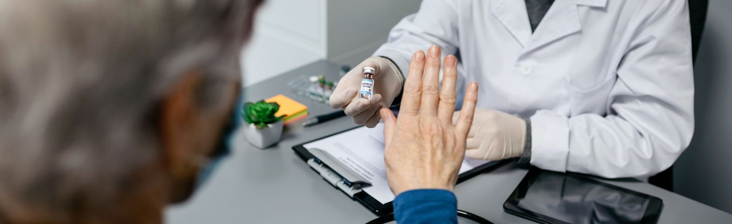 Patient refusing the coronavirus vaccine offered by doctor