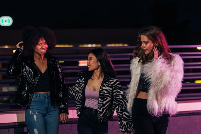 Multi-ethnic group of female friends on terrace at night at party