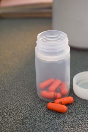 Red prescription pills in container on counter
