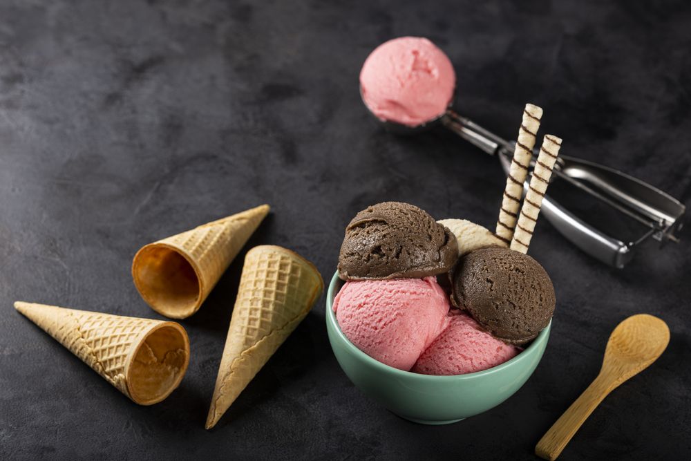Bowl with Neapolitan ice cream on dark background.