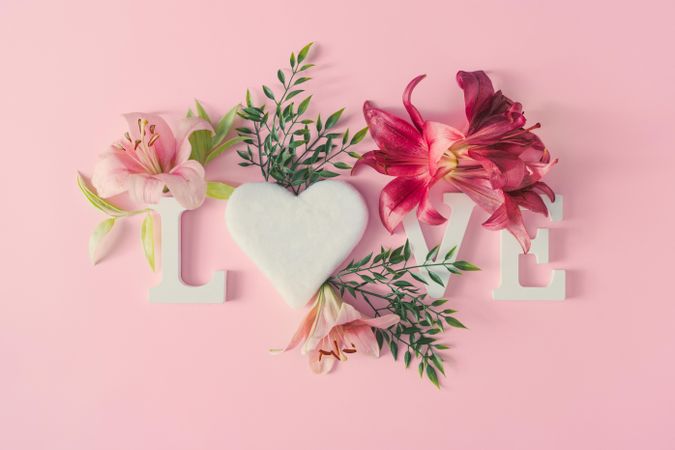 “Love” written on pink background with spring flowers