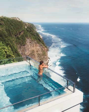Chilling man in pool against seascape