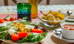 Traditional mexican food with a plate of fresh salad, nachos and