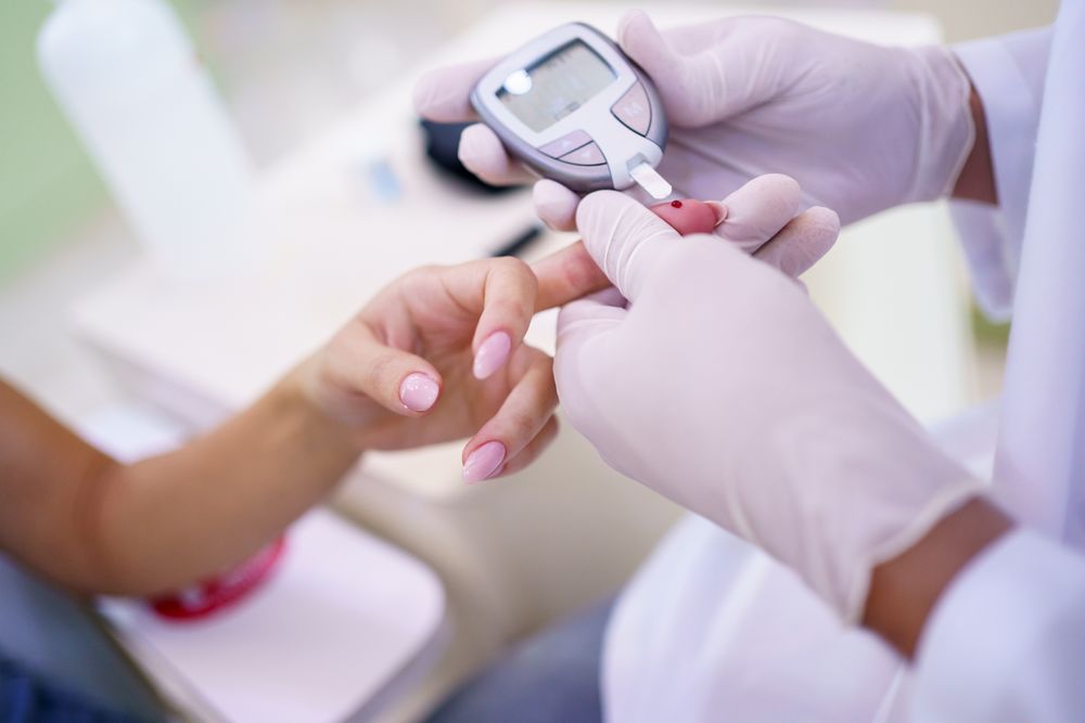 Doctor checking sugar level of patient in clinic