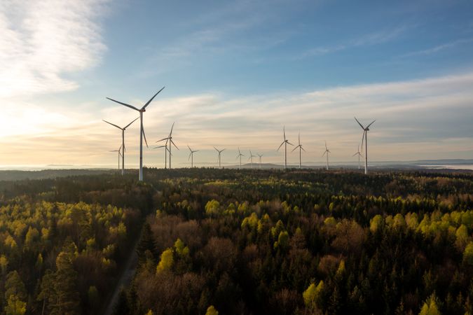 German wind turbine farm inside a forest, drone aerial view