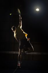 Man playing padel in darkness