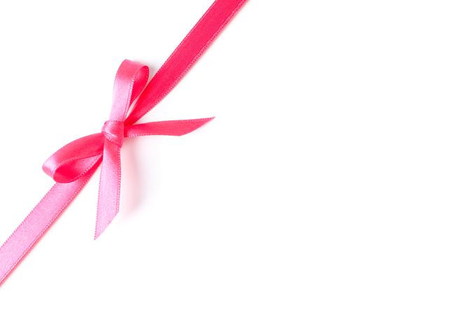 Pink ribbon with bow isolated on plain background. Gift concept