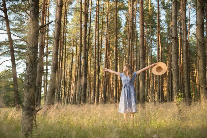 Smiling young woman relaxing among pine trees